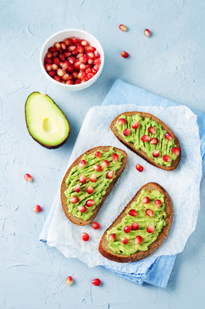 Smashed avocado pomegranate rye sandwiches. toning. selective focusの写真素材
