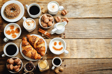 Wood background with different types of coffee and desserts to them. toning. selective focusの写真素材