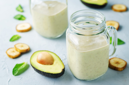 Avocado banana smoothies on a stone background. toning. selective focusの写真素材