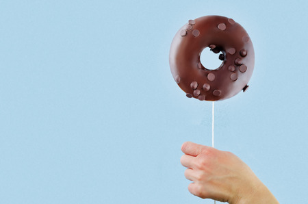 Donut in hand on a blueの写真素材