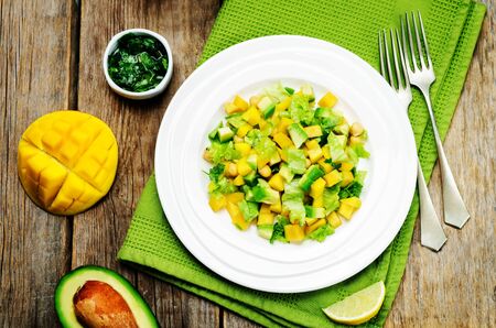 Mango avocado chickpeas salad on a wood background. Selective focusの写真素材