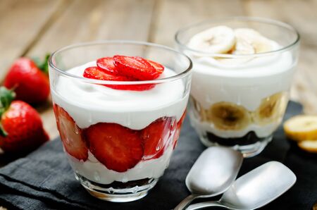 Greek yogurt strawberry and banana parfaits on a wood background. toning. selective focusの写真素材