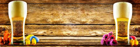 Glass of cold light beer with Easter decorations on a wood background for the Easter holidays. toning. selective focusの写真素材