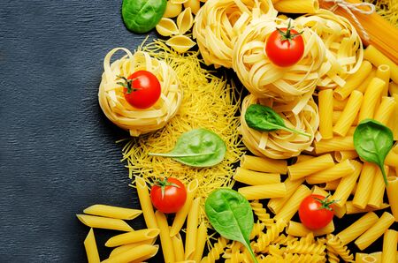 different pasta with tomatoes and spinach leaves. toning. selective Focusの写真素材