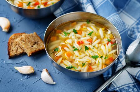 Turkey orzo vegetables soup with fresh rye bread slices. toning. selective focusの写真素材