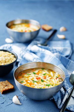 Turkey orzo vegetables soup with fresh rye bread slices. toning. selective focusの写真素材