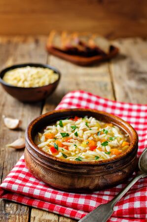 Turkey orzo vegetables soup with fresh rye bread slices. toning. selective focusの写真素材