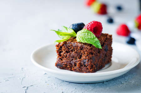 Chocolate brownie with berries and mint leaves. the toning. selective focusの写真素材