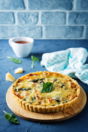 bacon spinach quiche with fresh spinach leaves. toning. selective focus