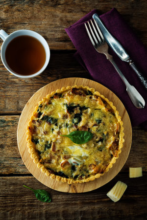 bacon spinach quiche with fresh spinach leaves. toning. selective focus