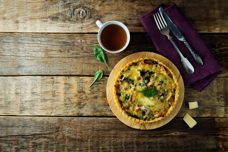 bacon spinach quiche with fresh spinach leaves. toning. selective focus