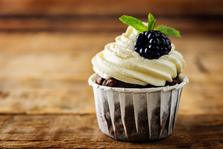 Chocolate banana cupcakes with cream cheese frosting and blackberries. toning. selective focusの写真素材