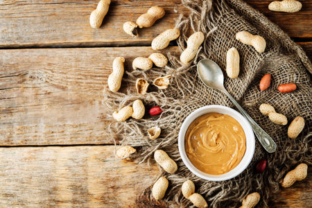 Peanut butter with peanuts on a dark wood background. toning. selective focus