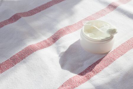 Flat lay with white face cream in jar. Spa concept. Beauty blogger, salon treatments concept. Minimalism.の写真素材
