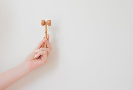 wooden face roller. Anti age, lifting and toning treatment. women skincare tool massaging oils and cream into skin.の写真素材