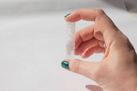 woman holds vaccine in her hand. ampoule with vaccine in hand close up. concept vaccination and treatment of coronovirusの写真素材
