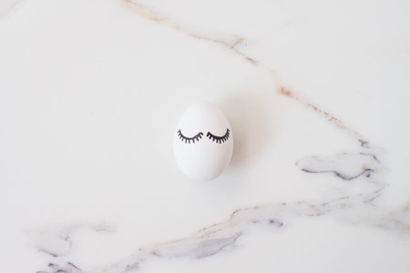 Easter eggs on white marble background in the shadow of a tropical palm tree with copyspace. set...