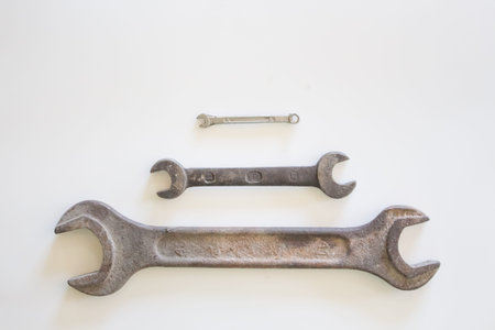 Old rusty wrench on a white and metal background. several wrenches of different sizes. Card with...