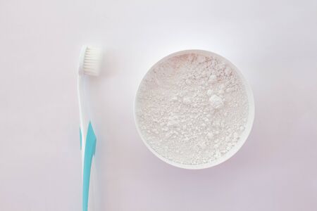 close-up of tooth powder in a jar and a toothbrush on a white background. text space, top view, layout.の写真素材