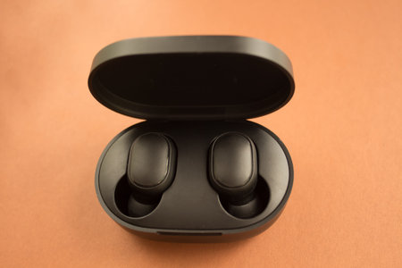  flat layout with wireless headphones in a black box. brown background. Card with copy space for...