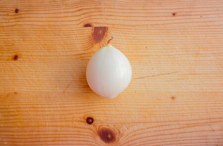 Peeled onion on a cutting board. Layout with text space, top view.の写真素材