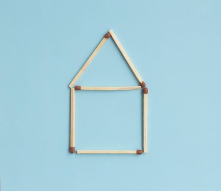 House of matches on a blue background with text space. Top view. Mock up. Flat lay composition.の写真素材