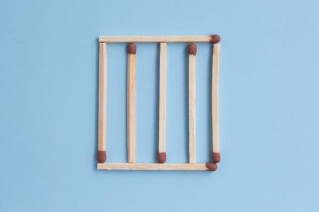 grille on a blue background. concept of prison and imprisonment. matches in a row