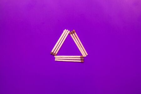 triangle of luminates on a purple background from matches. symbol of the masons, satanists.の写真素材
