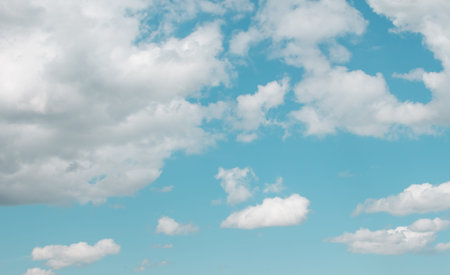  White clouds on a blue summer sky in one plane. Light skies with light fluffy clouds. copy space