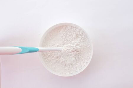 close-up of tooth powder in a jar and a toothbrush on a white background. text space, top view, layout.の写真素材
