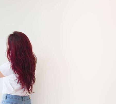 Brunette with long hair stands with his back to the camera, hair is bright color, slim figure concept health and beauty. の写真素材