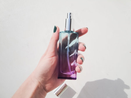 Blue glass bottle on a purple background. Card with copy space for text. Top view, flatlay.