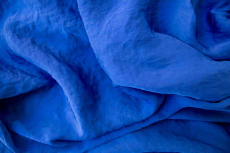 Blue satin with cotton and velvet in elegant folds shimmers with light and deep rich color. Top view. Flat layの写真素材