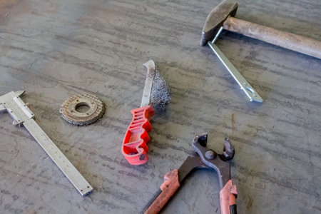  metal brush, wrench, pliers and other tools on an iron table. Top view. Mock up. Flat lay...