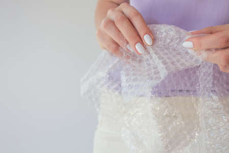Cellophane film for packaging with air in female hands with copy space.  Wrap Packing Close Up, Copy Spaceの写真素材