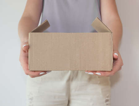 The girl hands the parcel from the online store to the buyer. The concept of delivery of products and other goodsの写真素材