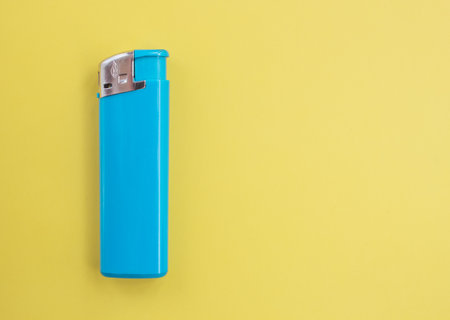 A turquoise lighter on a bright colored background with copy space. Smoking conceptの写真素材