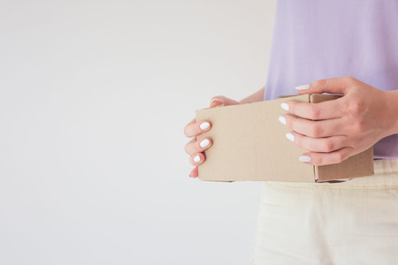 Ð¡ourier delivered the package and hands it over to the recipient. Cardboard box with parcel in...