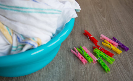 clean linen in a basin on the table with clothespinsの写真素材