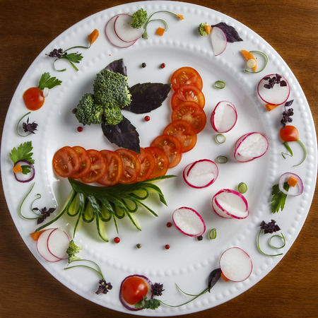White plate with artistically carved vegetables.の写真素材
