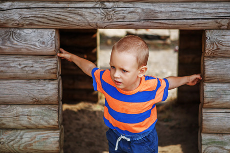 Cute little boy playing on the playground in the summer in the cityの写真素材