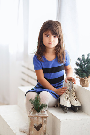 Little girl trying on a large ice skating. Little kid and skatesの写真素材