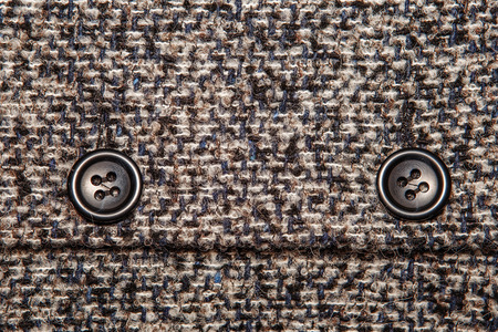 Varicolored tweed like texture, varicolored wool pattern, textured  melange upholstery fabric background copy space.  Background texture of twill with two big black buttonsの写真素材