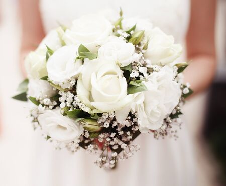 Bride holding bouquet of white roses outsideの写真素材