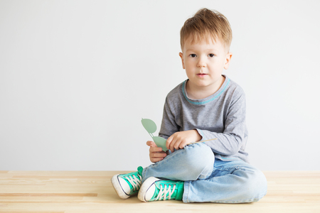 Portrait of a adorable little kid with blue paper glasses against a white background.の写真素材