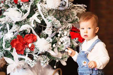 Little baby girl decorates a Christmas treeの写真素材