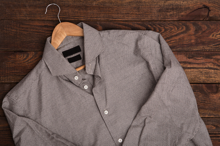 Business classic men's shirt with houndstooth pattern print. Casual outfit on brown wooden grunge backgroundの写真素材