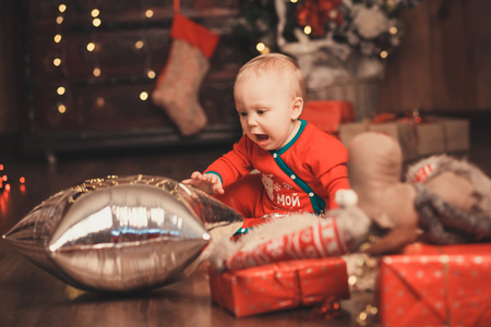 Lovely Baby boy in Santa Claus costume for Christmas playing with balloon. Happy familyの写真素材