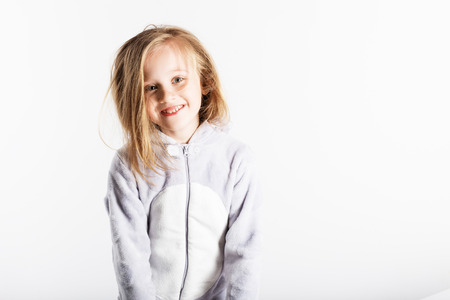 Cute little girl in pajamas jumping and having fun in bed at home. Pajama party, Day off, holiday, day of rest, free, off-timeの写真素材