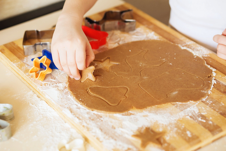 Cooking and decorating christmas gingerbread. Homemade gingerbread cookies, forms and baking ingredients. Gingerbread man and his wife. Gingerbread in the shape of a stylized human and other shapes.の写真素材